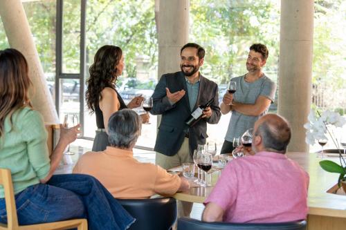 a group of people sitting around a table in a restaurant at Las Majadas Hotel & Centro de Reuniones in Pirque