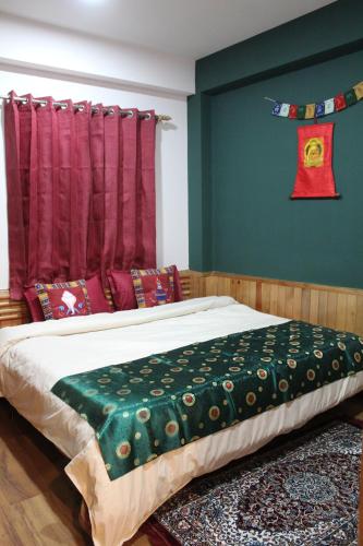 a bedroom with a bed with a red curtain at Flugafen B&B- A Peaceful home in Apple Orchards in Manāli
