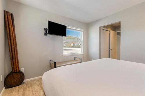 a bedroom with a bed and a flat screen tv at 4 Cayucos Bungalows Steps to Beach Sleeps 16 Pet Friendly in Cayucos
