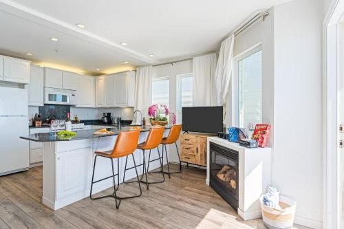 a kitchen with a fireplace and a kitchen with white cabinets at 4 Cayucos Bungalows Steps to Beach Sleeps 16 Pet Friendly in Cayucos