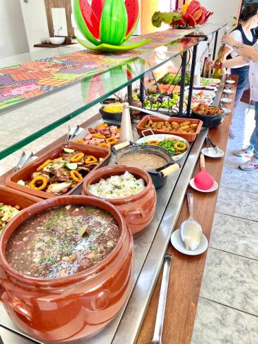 a buffet line with many different types of food at Pousada Dolce Vita in Itanhaém