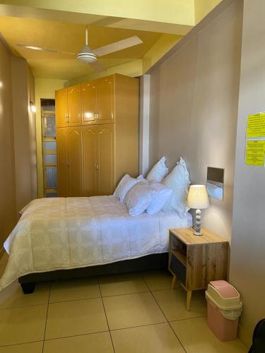 a bedroom with a bed and a table with a lamp at Frontline Holiday apartment in Durban