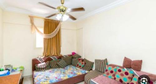 un soggiorno con un divano e un ventilatore a soffitto di مويلح a Sharjah