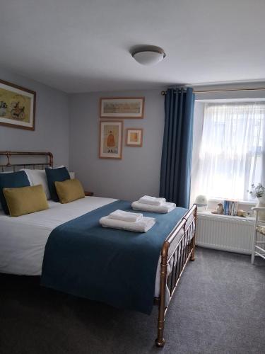 a bedroom with a large bed with towels on it at Ivy Cottage, in Lostwithiel