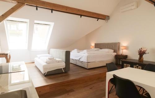 two beds in a room with a table and chairs at Central Riverside Apartments Meščanka in Ljubljana