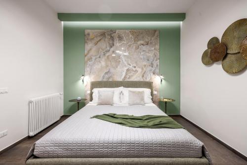 a bedroom with a large bed with green walls at Casta Diva Fervore Apartments Self Check-in in Palermo