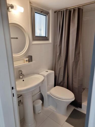 a white bathroom with a toilet and a sink at Paradise Garden Sweet Studio in Limassol
