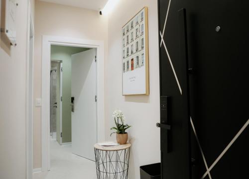 a hallway with a black door and a potted plant at Elite Guesthouse in Tirana
