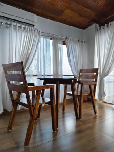 a dining room with a wooden table and two chairs at Peak Paradise Resort in Varkala