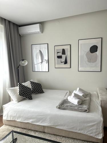 a bedroom with a bed with three pictures on the wall at Japandi Home in Niš