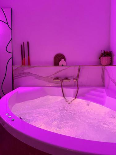 a purple room with a bathtub with purple lighting at Mini loft Spa - Cosy in Dijon