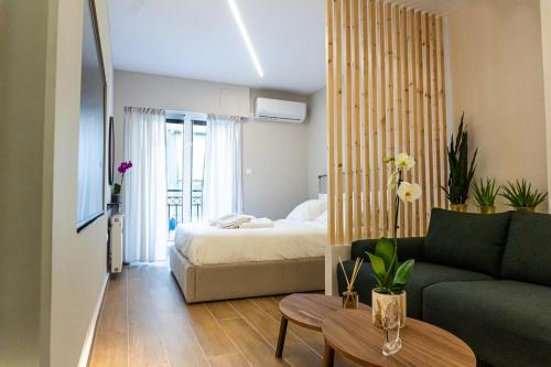 a living room with a bed and a couch at Elegant Suite - Piraeus in Piraeus