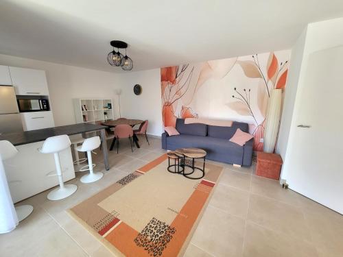 un salon avec un canapé bleu et une table dans l'établissement Le Terra Tosca, bel appartement, 2 pas de la plage, à Fréjus