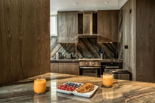 a kitchen with a table with a plate of bread and orange juice at FIVE Palm Jumeirah Premier Apartments in Dubai