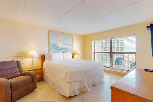 a bedroom with a bed and a chair and a window at Saida Towers IV #4906 in South Padre Island