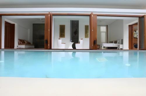 an empty swimming pool with glass doors and a swimming pool at Kehadfa One in HHQ