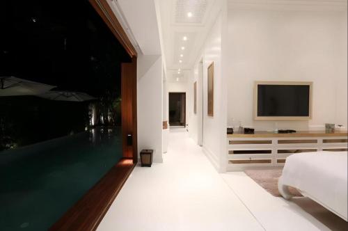 a bedroom with a swimming pool and a tv at Kehadfa One in HHQ