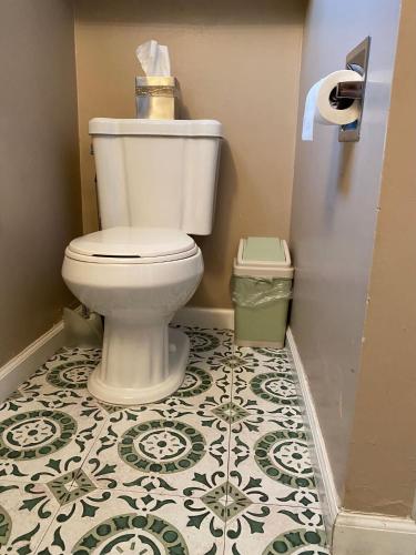 a bathroom with a toilet and a tile floor at Seq Parks-House with Hot Tub Fire Pit Koi Pond Outdoor Kitchen in Visalia