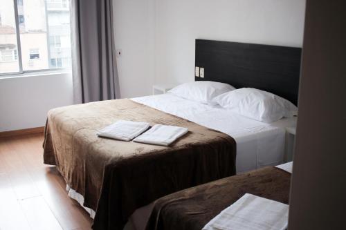 a hotel room with two beds with towels on them at Letto Business Antigo Hotel Ornatus Proximo a Santa Casa in Porto Alegre