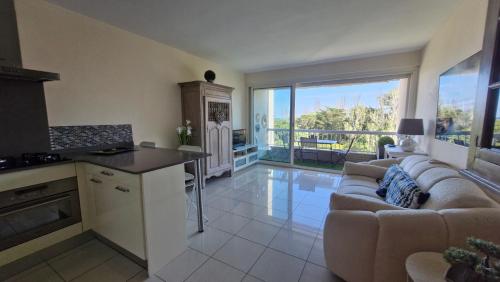 une cuisine et un salon avec un canapé et une table dans l'établissement Véritable pépite proche plage et port, à Saint Cyprien Plage