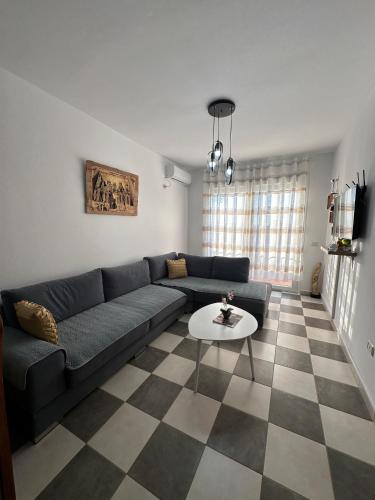 una sala de estar con un sofá y una mesa en Sunset Beach Apartment, en Durrës
