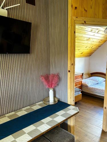 a room with a table with a vase of flowers on it at DOLINA ROZTOKI-mieszkanie,pokoje lub domek z lokalem na poddaszu in Bircza