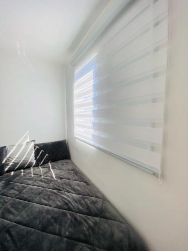 a bedroom with a bed and a window at Apartamento Mobiliado em Extrema MG in Extrema