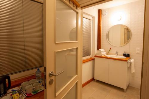 a bathroom with a door and a sink and a mirror at Harry nie z tej bajki & Bałtycka44 Apartments in Olsztyn
