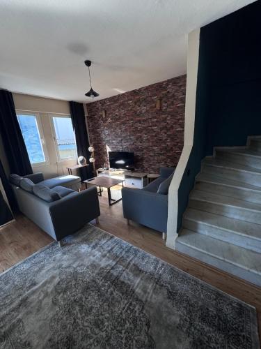 a living room with a staircase and a brick wall at Holiday Home in Stylish and Peaceful Center in Kusadası