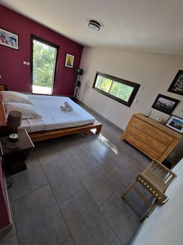 - une chambre avec un lit, un banc et 2 fenêtres dans l'établissement Villa avec piscine et dépendance, à Nîmes