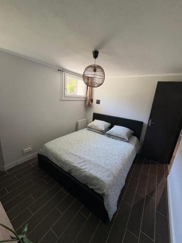 - une chambre avec un lit et une lampe pendant dans l'établissement Appartement Rouen gare/centre, à Rouen