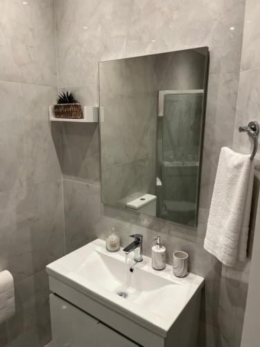 a bathroom with a sink and a mirror at Skyway Comfort Residences in Spáta