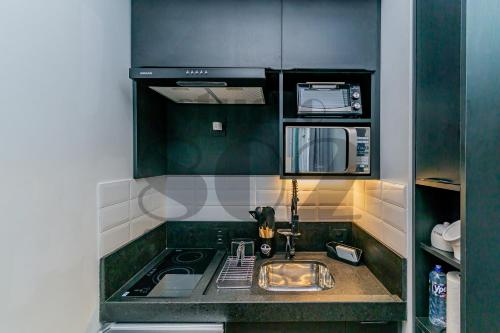 a kitchen with a sink and a microwave at Studio Lido - 802 Reformado em POA in Porto Alegre