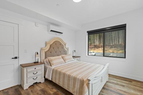 a white bedroom with a bed and a window at Cozy Spacious Retreat with Fireplace 205 in Juneau