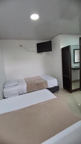 a hotel room with two beds and a tv at Hotel Blue in Santa Rosa de Cabal
