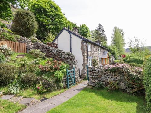 a stone house with a gate in a garden at Haulfryn in Llangynog