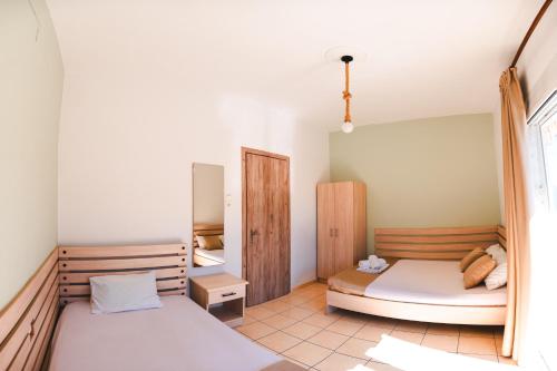 a bedroom with two beds and a window at Μpasias Apartments in Paralia Katerinis