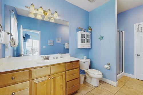 Un baño azul con inodoro y lavabo. en Doctor's Orders, en Dauphin Island