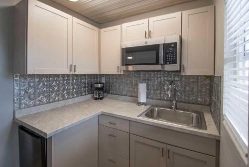 a kitchen with a sink and a microwave at Liberty hill Executive Inn in Zephyrhills
