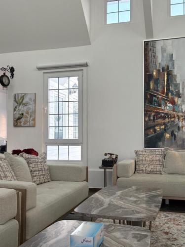 a living room with two couches and a window at Prairie in Al Khaznah