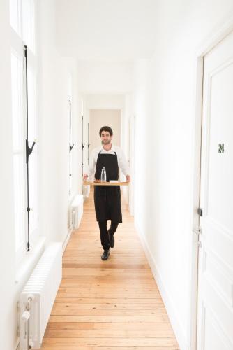 a man walking down a hallway holding a clipboard at Hotel des Galeries in Brussels