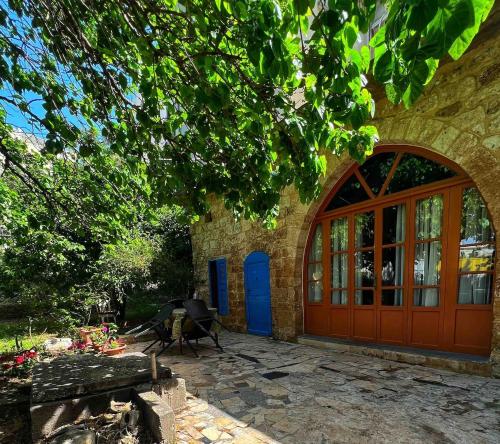 een bakstenen gebouw met een rode deur en een bank bij Beit Tout Guesthouse in Saïda