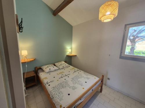 une chambre avec un lit et une fenêtre dans l'établissement MAS DE LA PLAGE, à Portiragnes