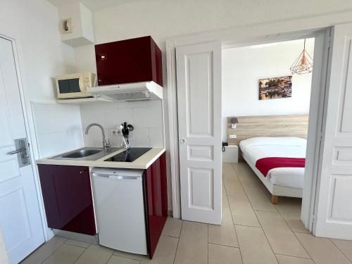 une cuisine avec un évier et une chambre avec un lit dans l'établissement T2 Route des sanguinaires - Piscine chauffée - Vue Mer - Les Calanques- Parking inclus - Wifi, à Ajaccio
