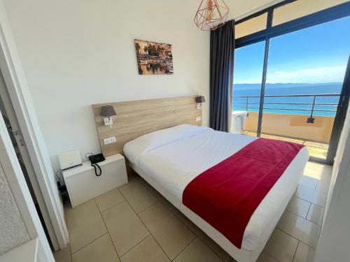 une chambre avec un lit avec vue sur l'océan dans l'établissement T2 Route des sanguinaires - Piscine chauffée - Vue Mer - Les Calanques- Parking inclus - Wifi, à Ajaccio
