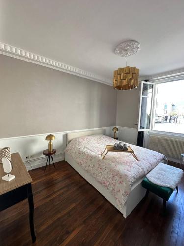 une chambre avec un lit, une table et une fenêtre dans l'établissement Le pétillant - cathédrale, à Reims