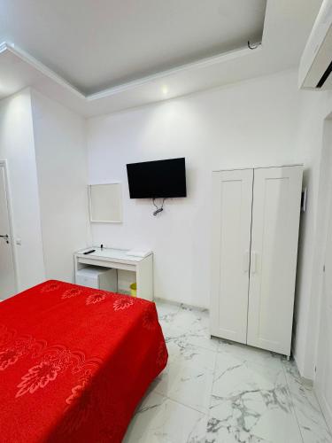a bedroom with a red bed and a tv on the wall at Casa Roma in Rome