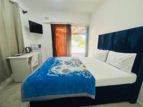 a bedroom with a bed with a blue and white blanket at Executive Accommodation Bellville 2 in Cape Town