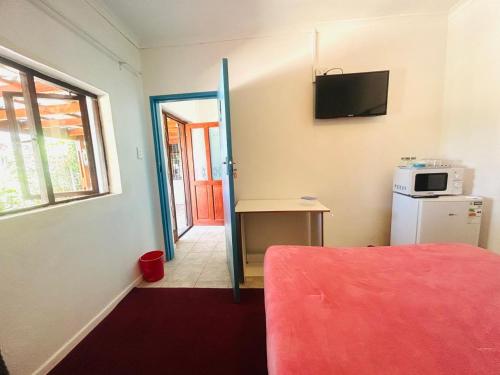 a room with a bed and a television on the wall at Executive Accommodation Bellville 2 in Cape Town