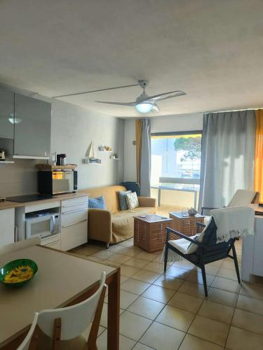 une cuisine et un salon avec un canapé et une table dans l'établissement Résidence Palmyra - APpartement 2 pièces les pieds dans l'eau MAE-2401, au Barcarès